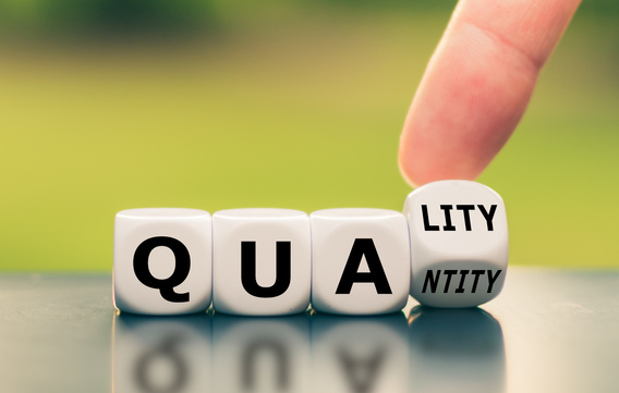 Quality over quantity. Hand turns a dice and changes the word "quantity" to "quality".